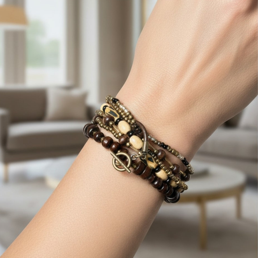 Handcrafted five-strand statement bracelet with wood, glass, and polymer clay beads worn on a wrist, featuring warm earthy tones and a leather toggle clasp.
