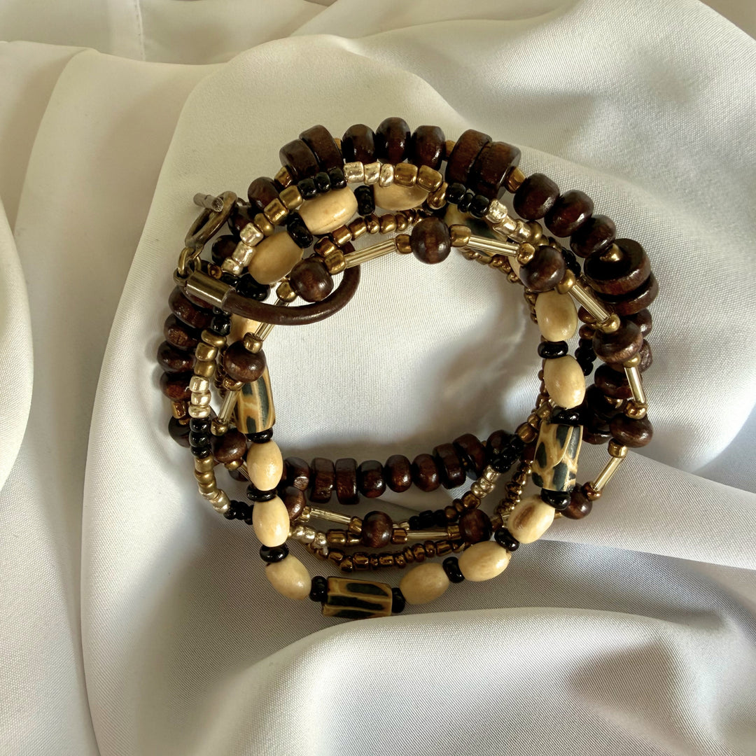 Full view of a handcrafted 5-strand stacked bracelet featuring wood, glass, and polymer clay beads in warm earthy tones.