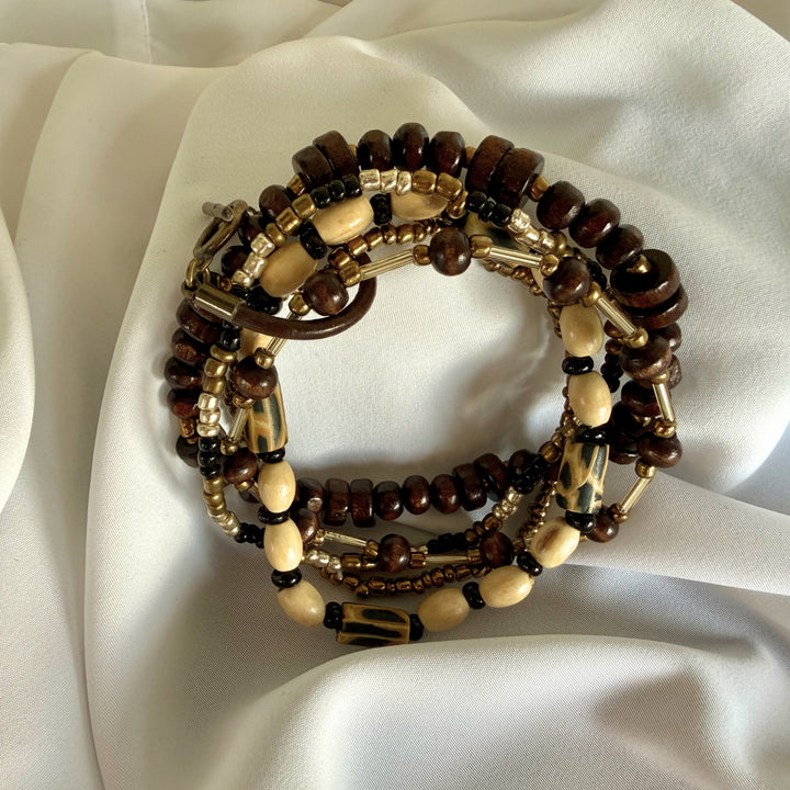 Full view of a handcrafted 5-strand stacked bracelet featuring wood, glass, and polymer clay beads in warm earthy tones.