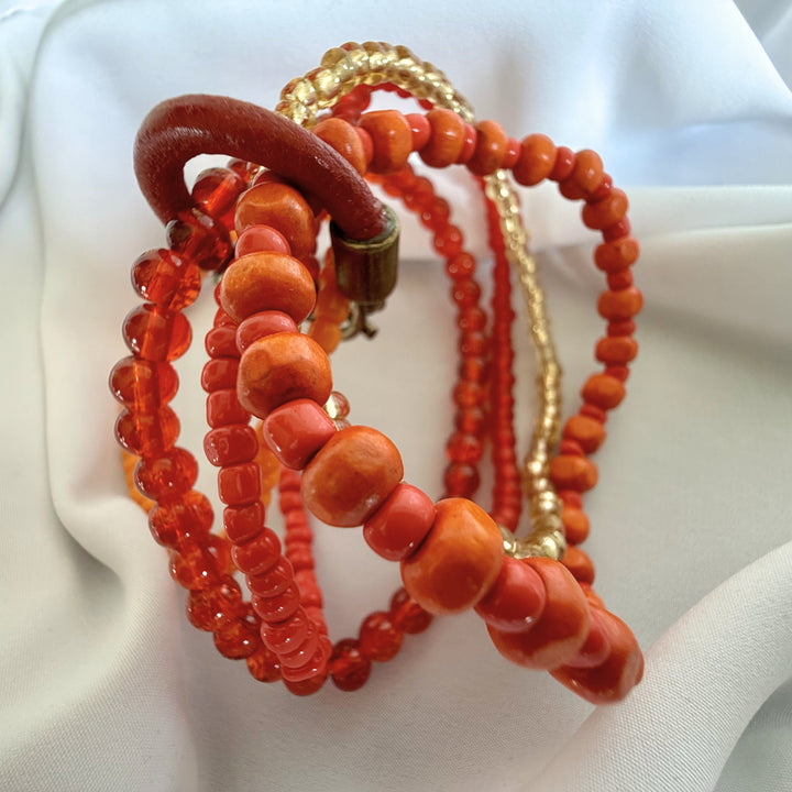 Close-up of the leather ring clasp on a handcrafted five-strand beaded bracelet, showing the adjustable opening mechanism and joining detail.