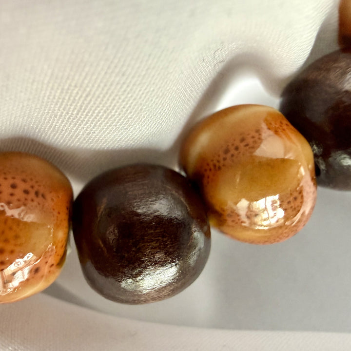Close-up detail of ceramic and wood beads showing texture and finish