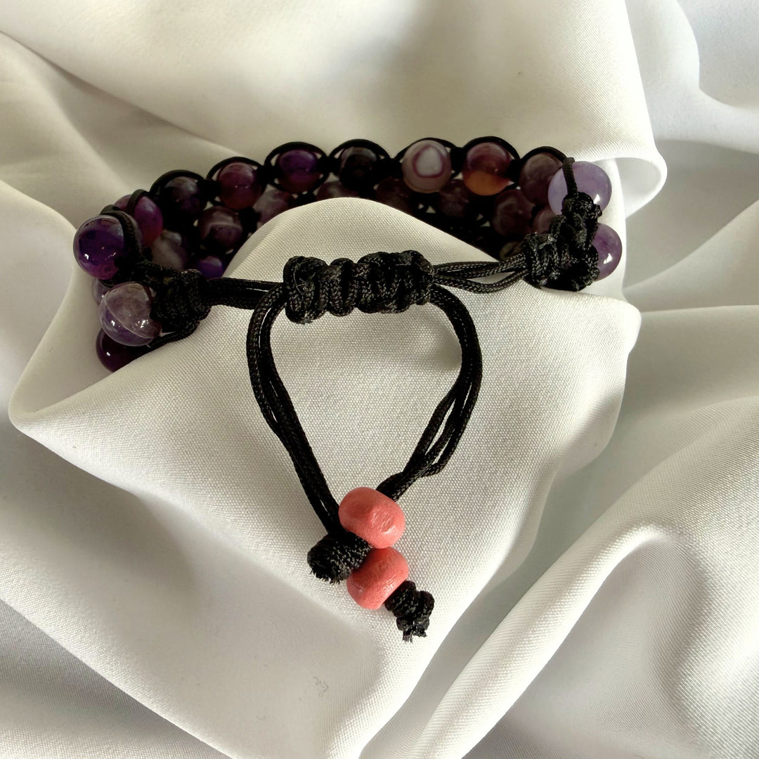 Close-up of the adjustable cotton cord on a handmade amethyst macramé bracelet.