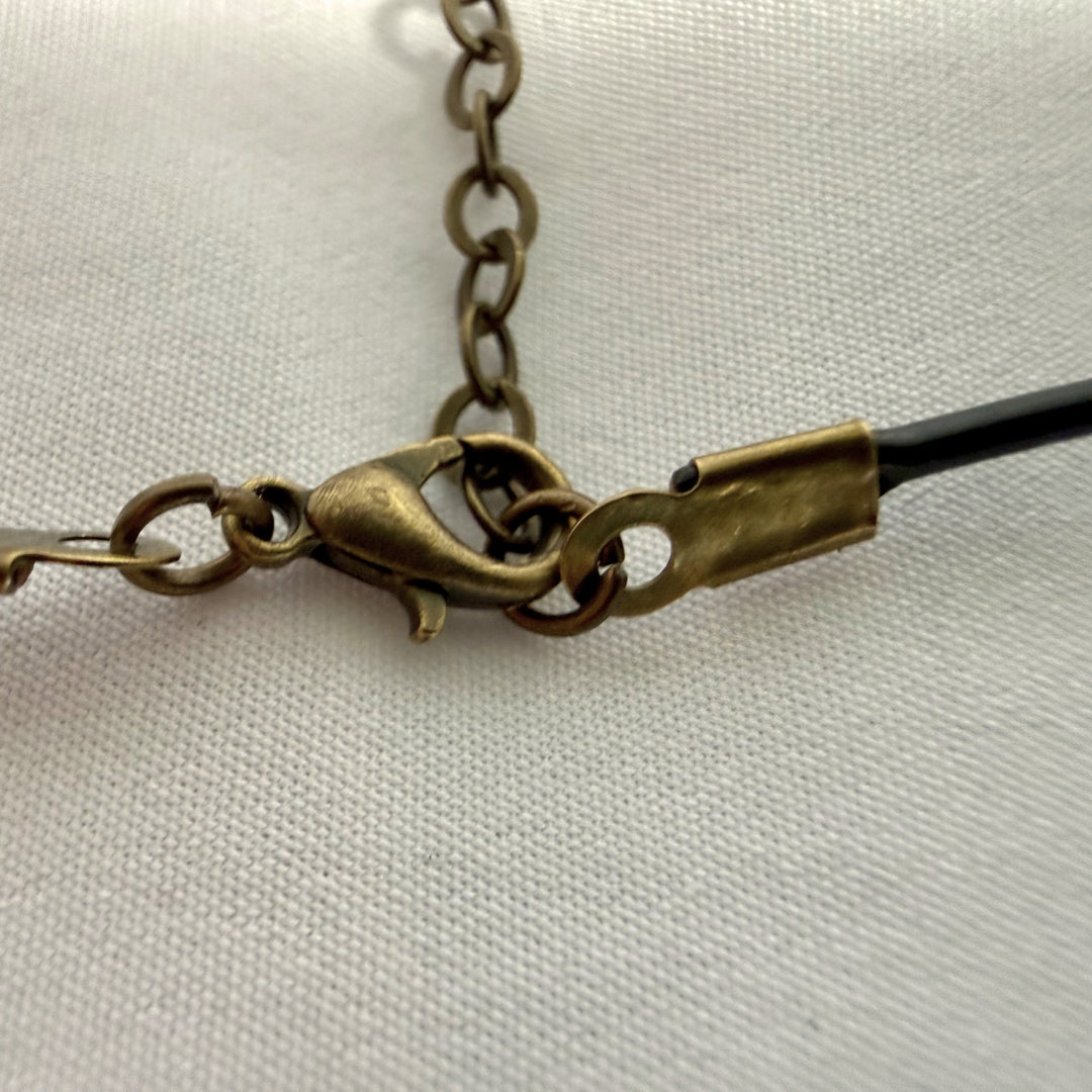 Detail of adjustable leather cord on black wooden pendant necklace