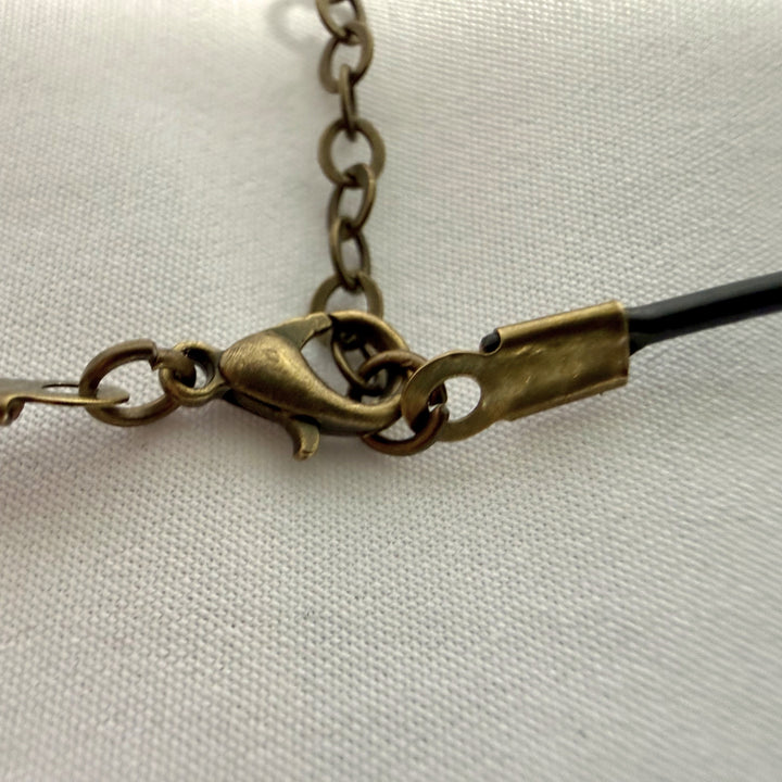 Detail of adjustable leather cord on black wooden pendant necklace