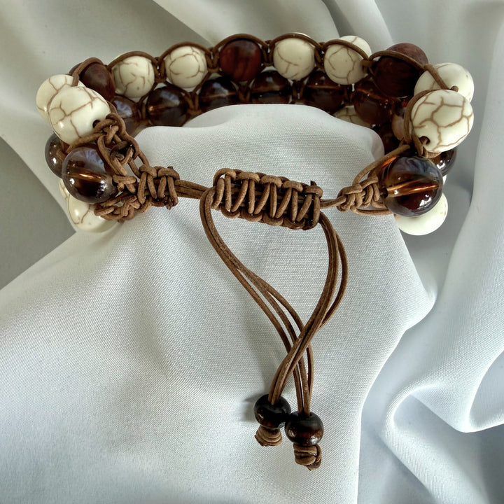 Close-up of the adjustable leather macramé cord on a handcrafted howlite bead bracelet.