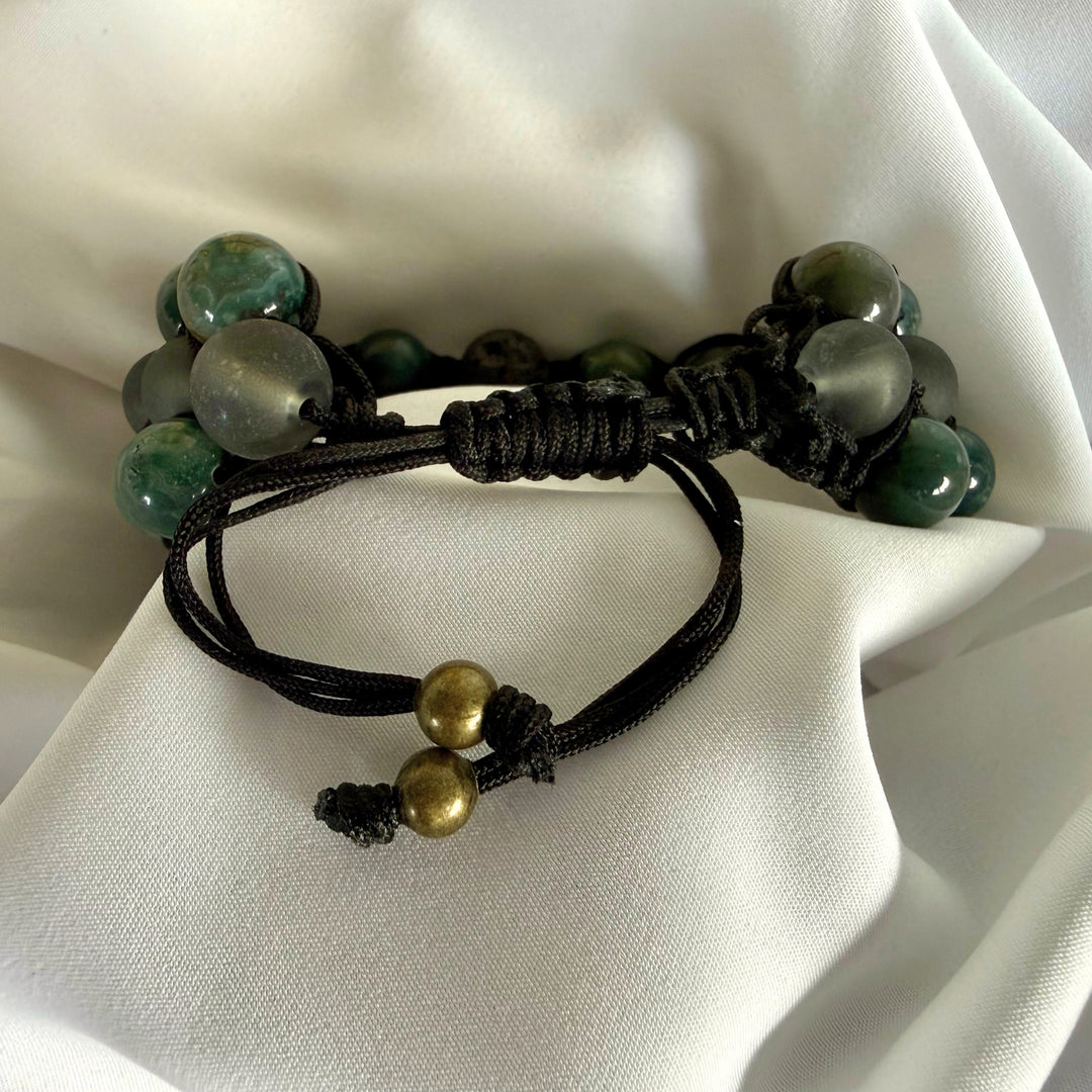 Close-up of the adjustable nylon cord and macramé knotting on a moss agate bracelet.