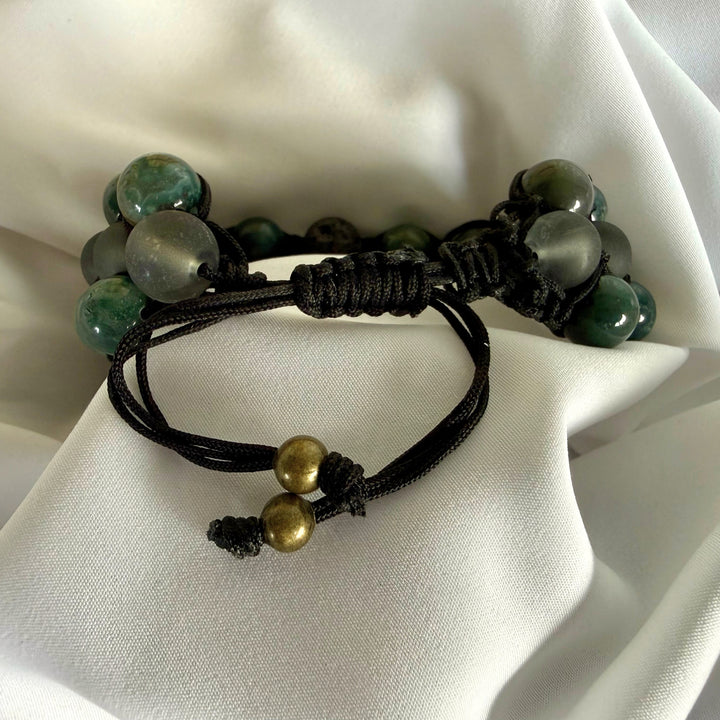 Close-up of the adjustable nylon cord and macramé knotting on a moss agate bracelet.