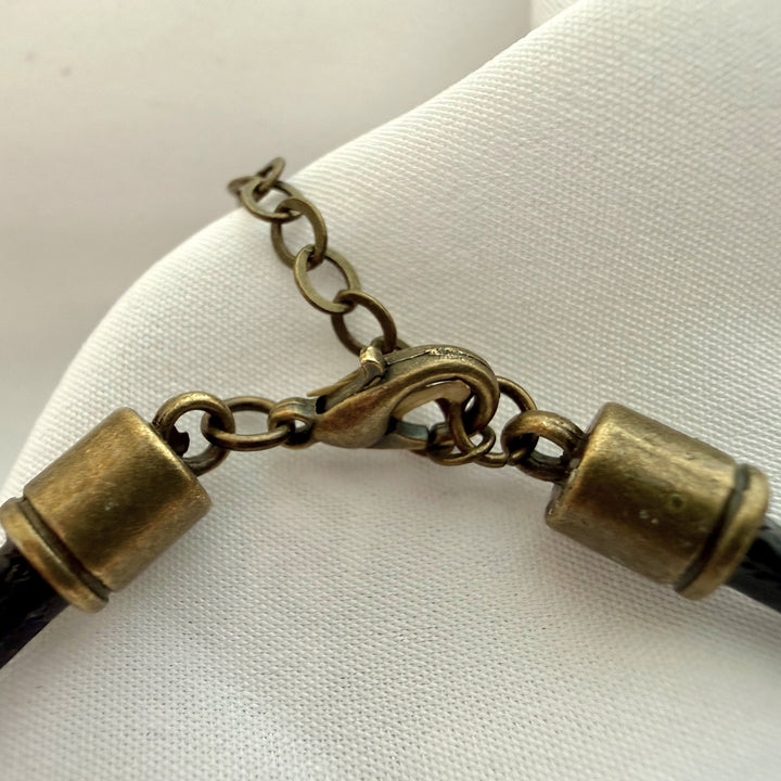 Close-up of stainless steel adjustable clasp on a handcrafted cork bracelet showing secure fastening detail.