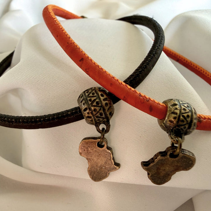 Handcrafted black cork bracelet featuring an Africa charm in antique brass with minimal bead detail.