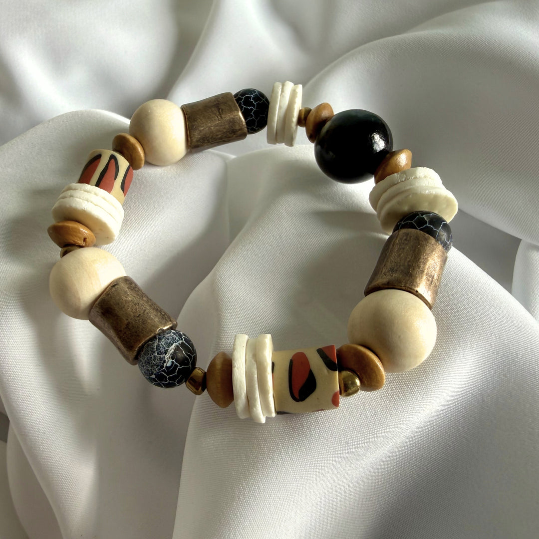 Full view of a handcrafted bracelet featuring crackle agate gemstones, wood beads, and animal print polymer clay beads.