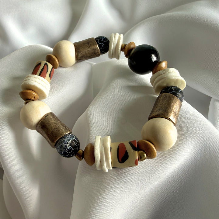 Full view of a handcrafted bracelet featuring crackle agate gemstones, wood beads, and animal print polymer clay beads.