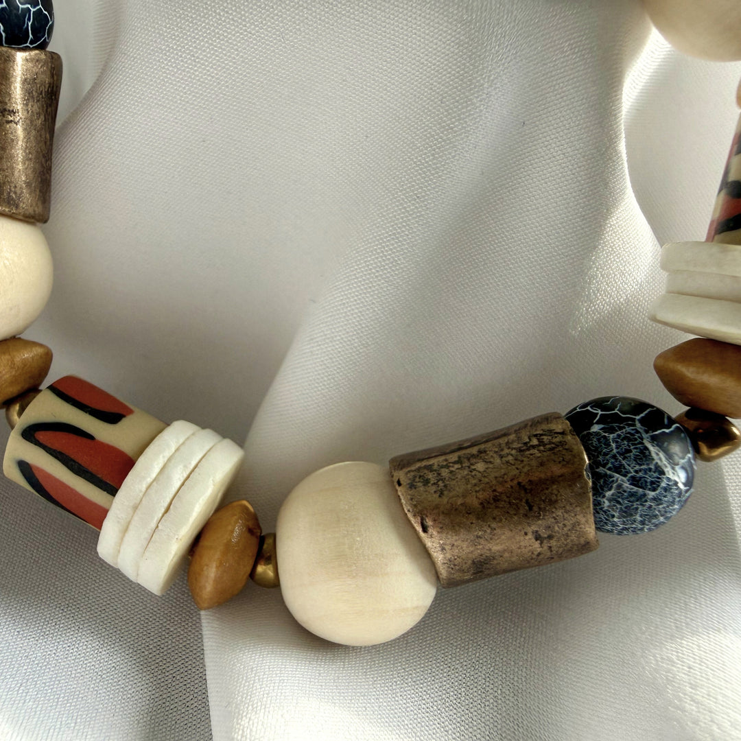 Angled close-up of a handcrafted bracelet highlighting texture contrast between agate, wood, and decorative polymer clay beads.