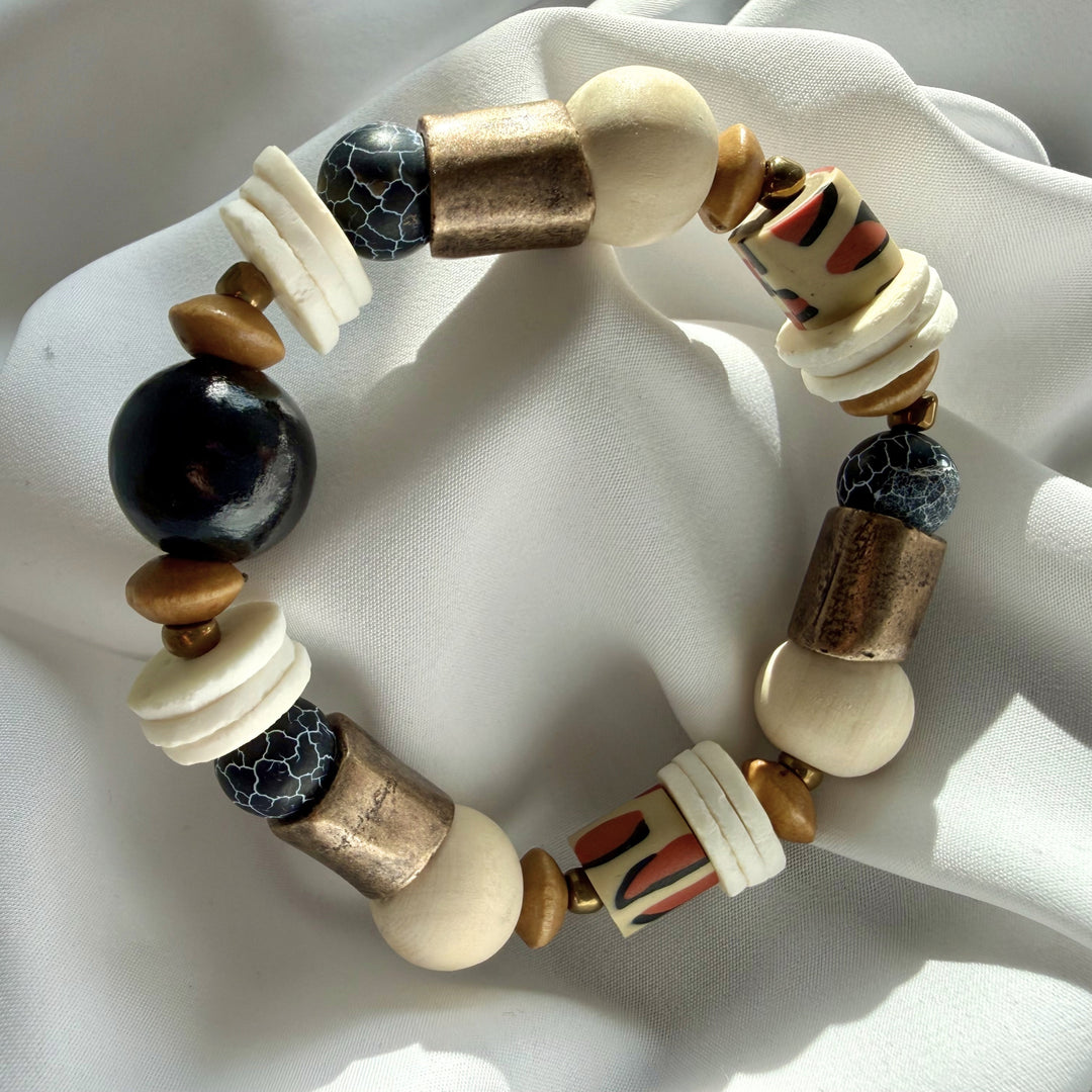Top view of a handcrafted artisan bracelet showing mixed crackle agate, wood, and patterned polymer clay beads.