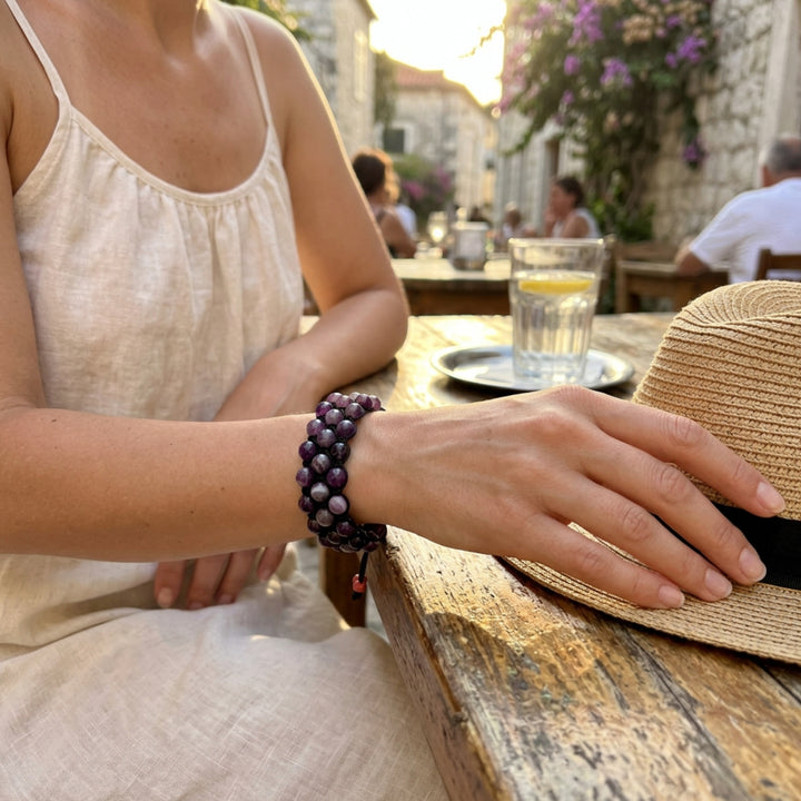 Purple amethyst macramé bracelet worn on a woman’s wrist in an outdoor café setting on the streets of Split, with a relaxed summer atmosphere.
