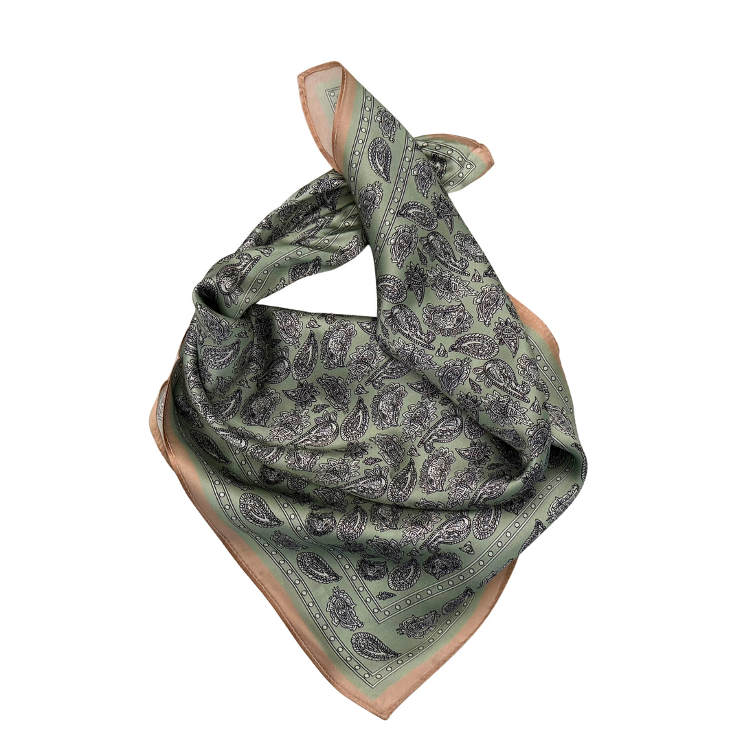 Paisley silk scarf neatly folded showing the detailed pattern and copper border.