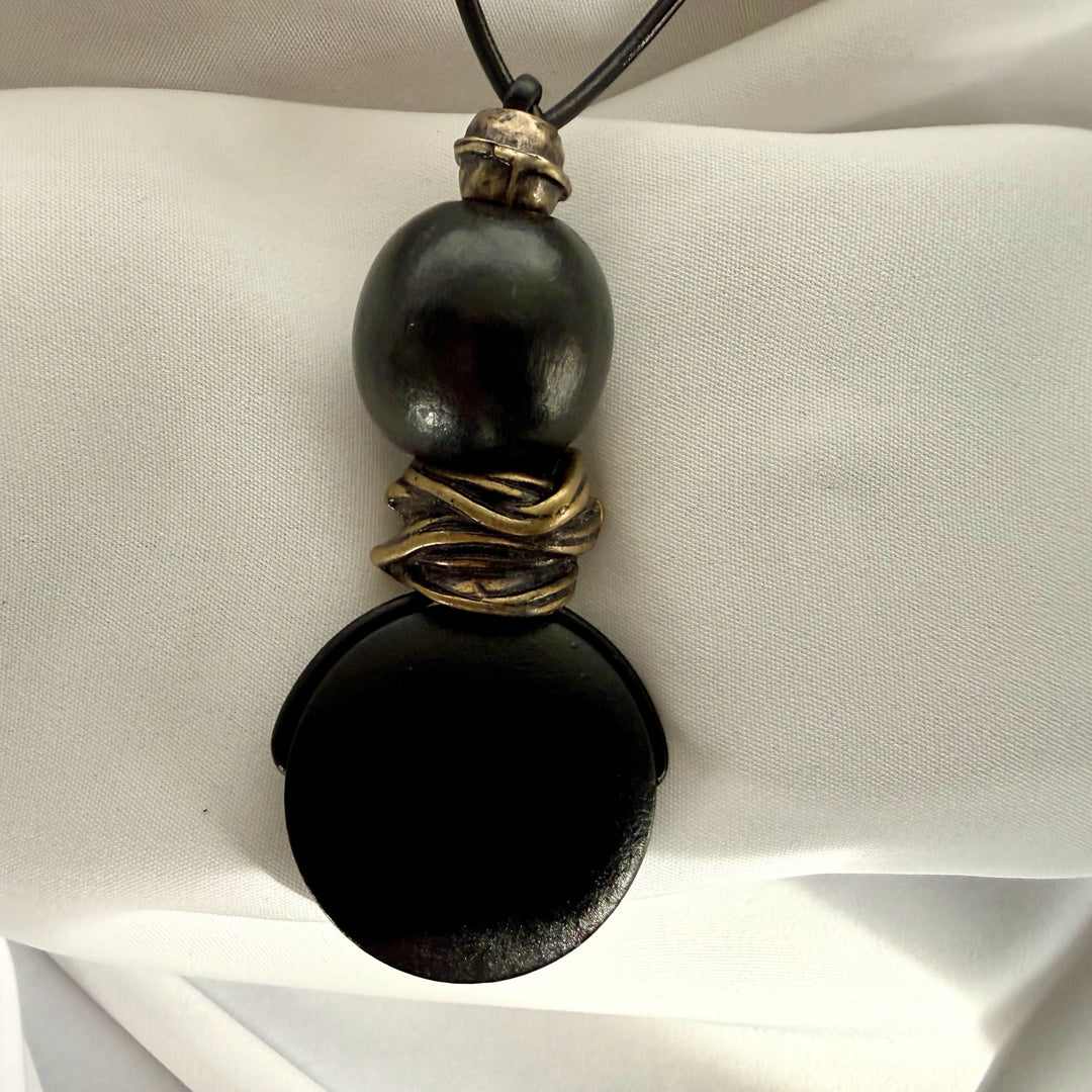 Back view of black wooden pendant necklace with adjustable leather cord