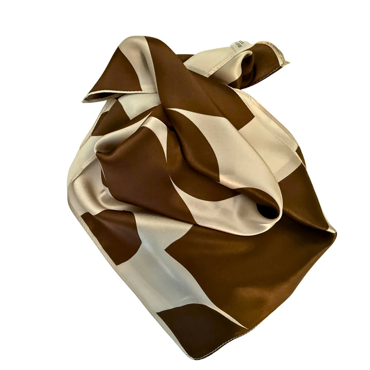 Brown geometric silk scarf neatly folded to highlight the pattern.