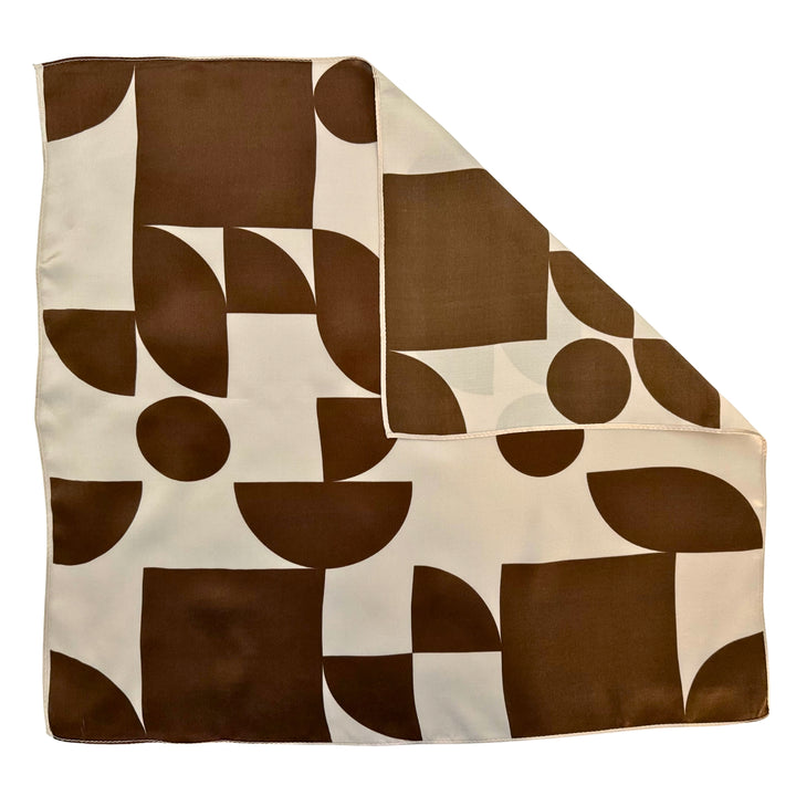 Brown geometric silk scarf with folded corner showing the reverse side and one-sided print.