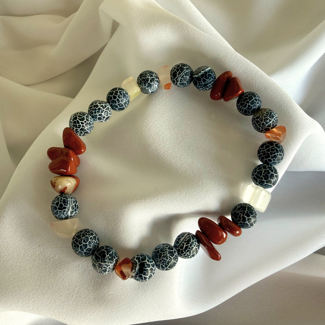 Full view of a handcrafted bracelet made with carnelian chip beads and black crackle agate gemstones.