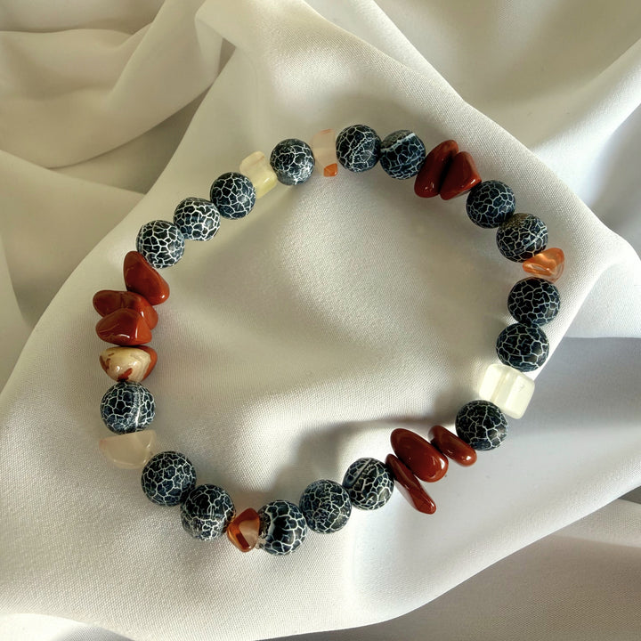 Full view of a handcrafted bracelet made with carnelian chip beads and black crackle agate gemstones.