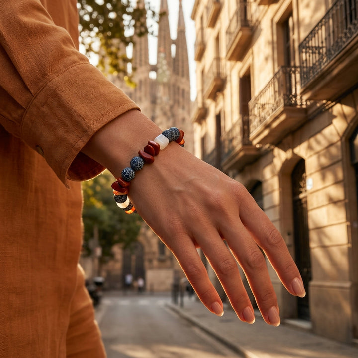 Handcrafted carnelian and black crackle agate bead bracelet worn on a woman’s wrist while walking the streets of Barcelona.