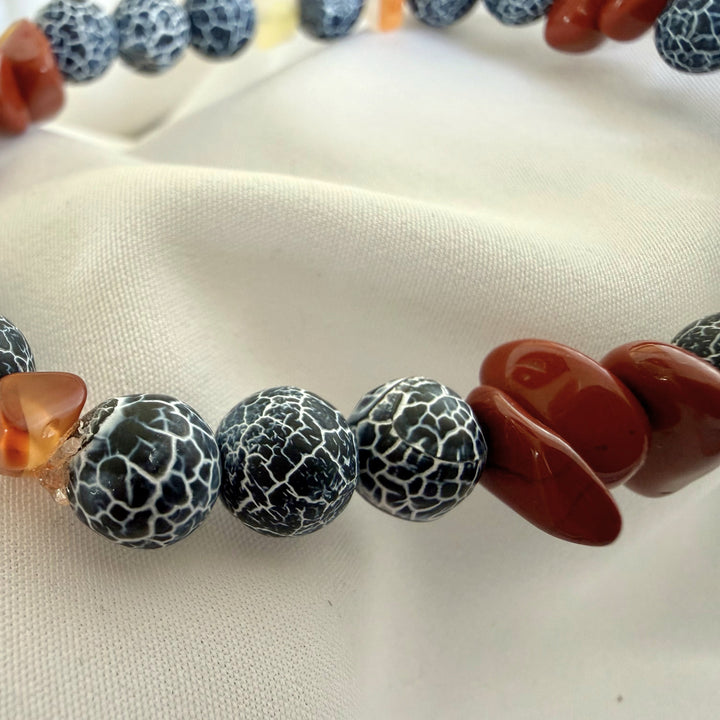 Side close-up view of a handcrafted bracelet highlighting texture contrast between carnelian chip beads and black agate stones.