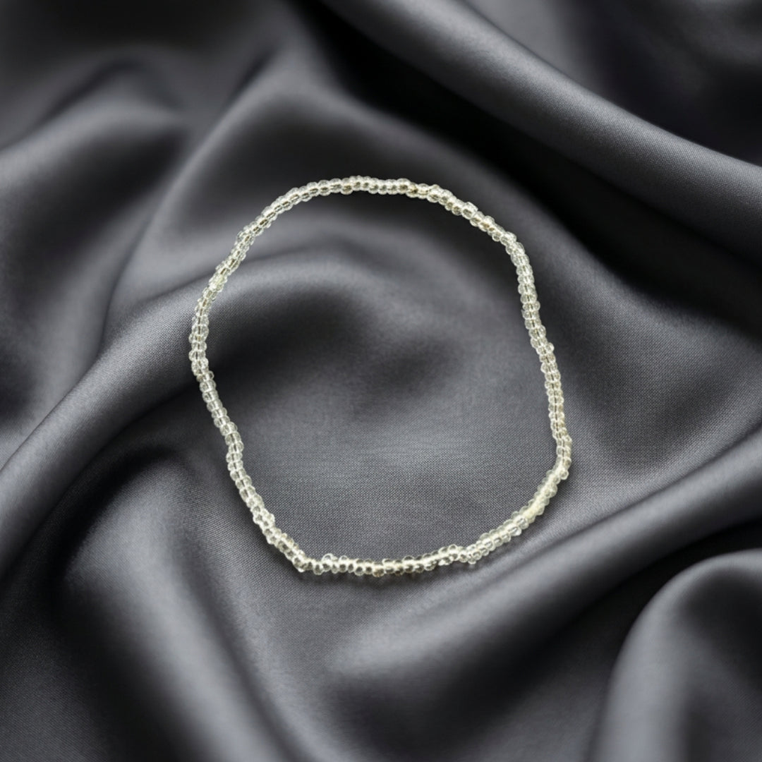 Full view of a handcrafted bracelet made with small transparent beads on elastic cord, designed for subtle layered styling.