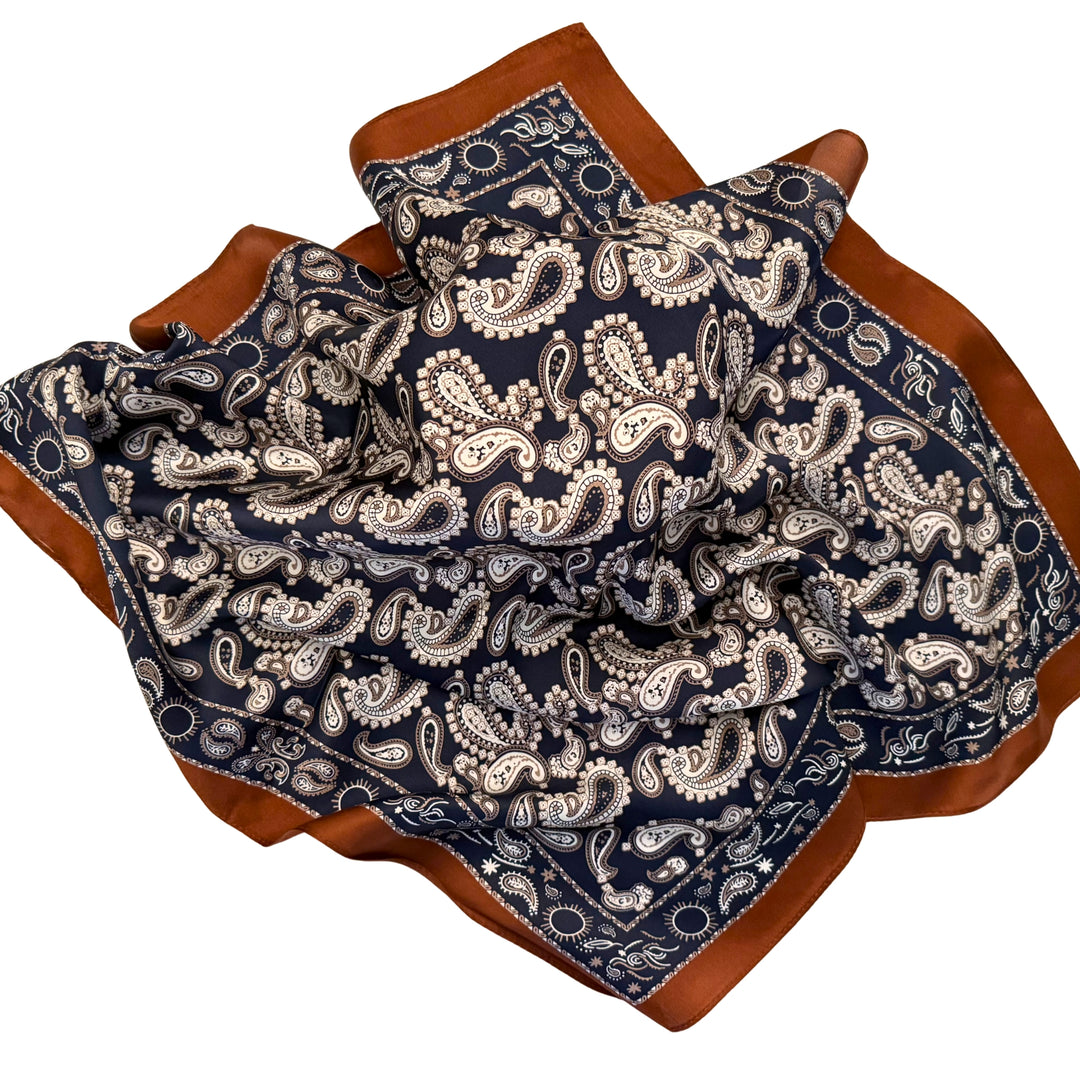 Dark blue paisley silk scarf loosely spread to display the full design.
