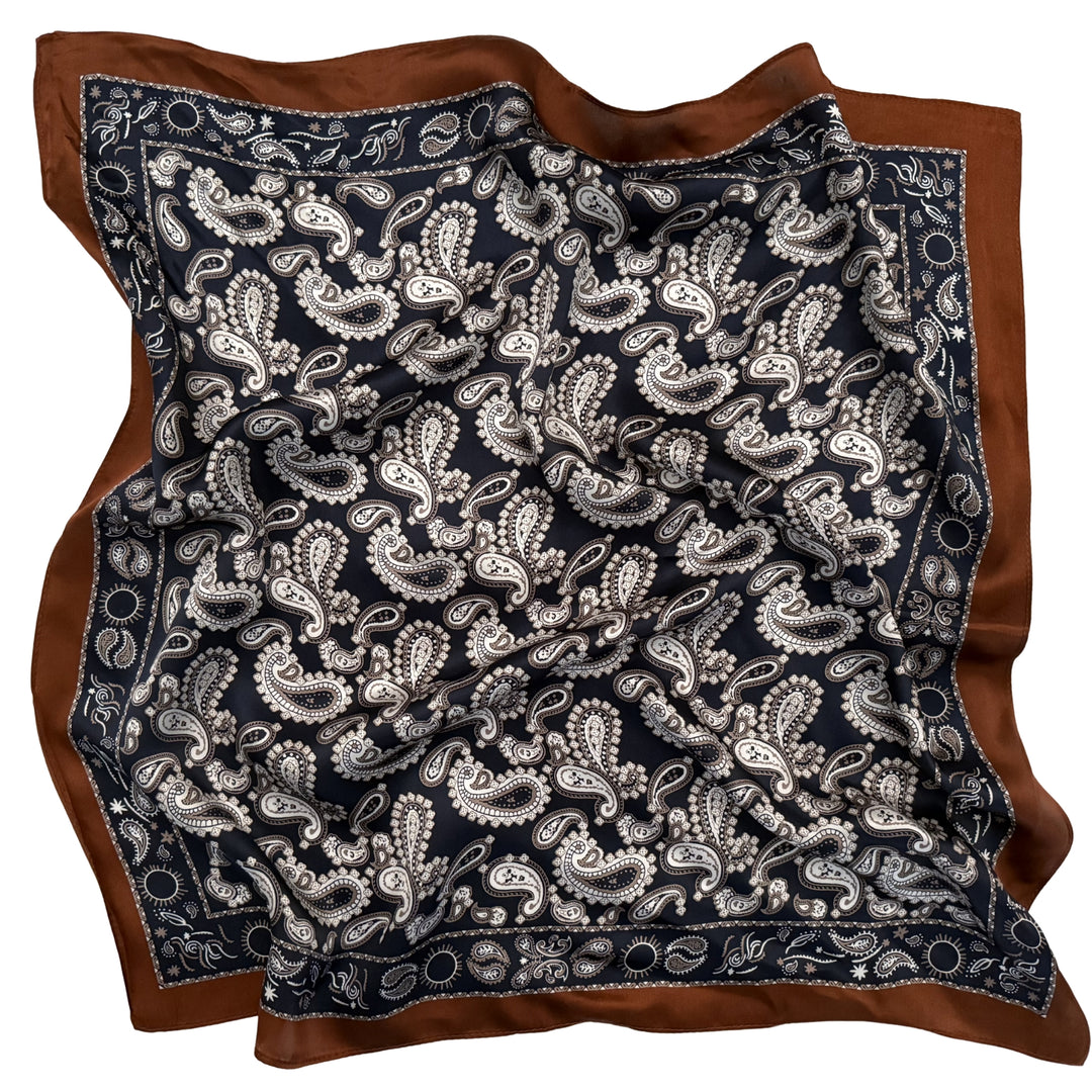 Dark blue paisley silk scarf softly laid out in a relaxed arrangement.