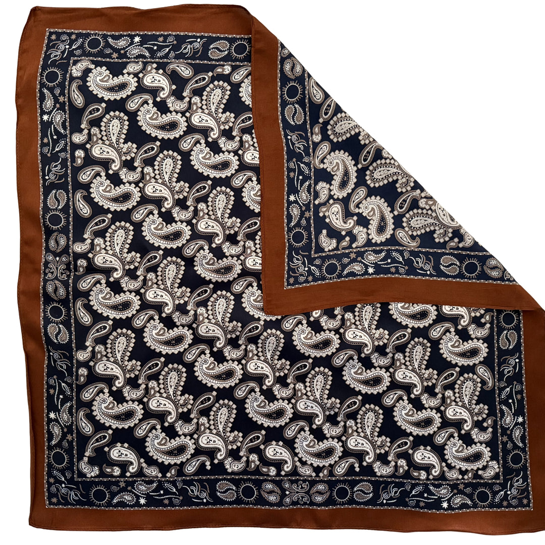 Dark blue paisley silk scarf with folded corner showing reverse side and one-sided print.