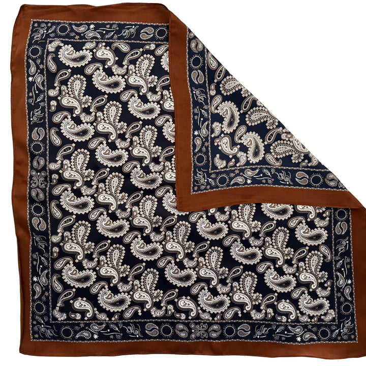 Dark blue paisley silk scarf with folded corner showing reverse side and one-sided print.