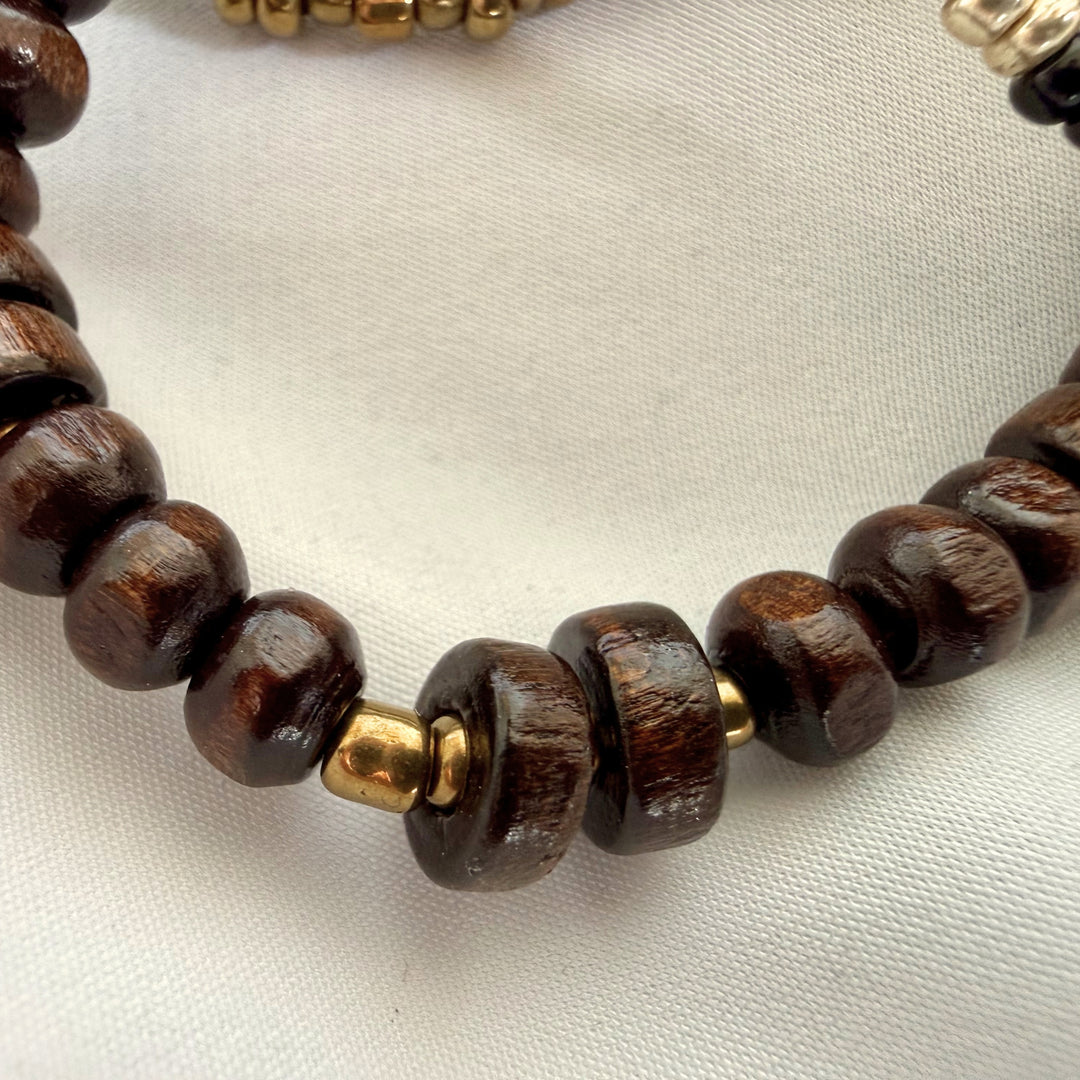 Close-up of dark brown wood beads on a handcrafted elastic bracelet with natural grain texture.