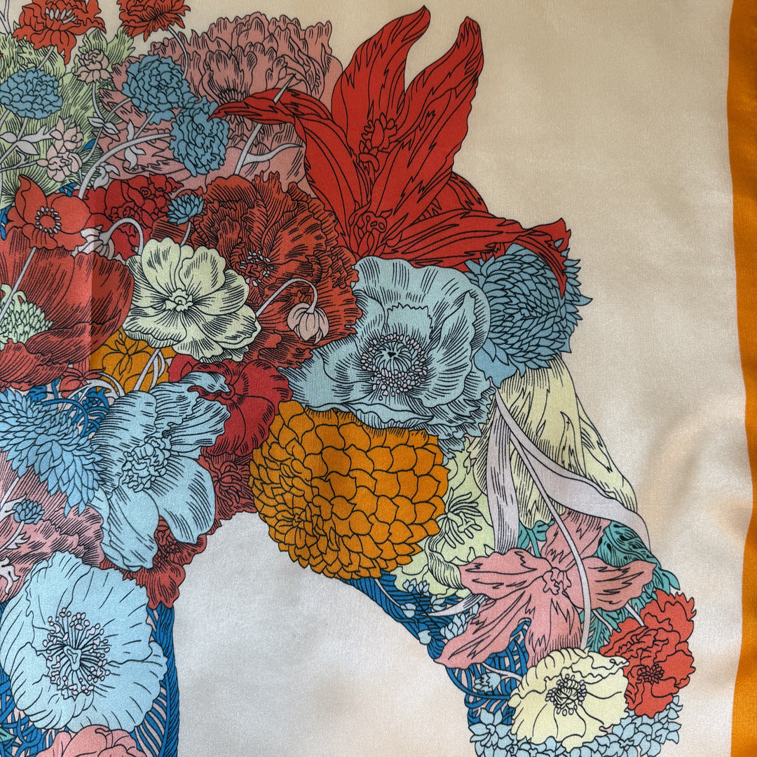 Close-up of horse head formed from colourful floral elements on silk.