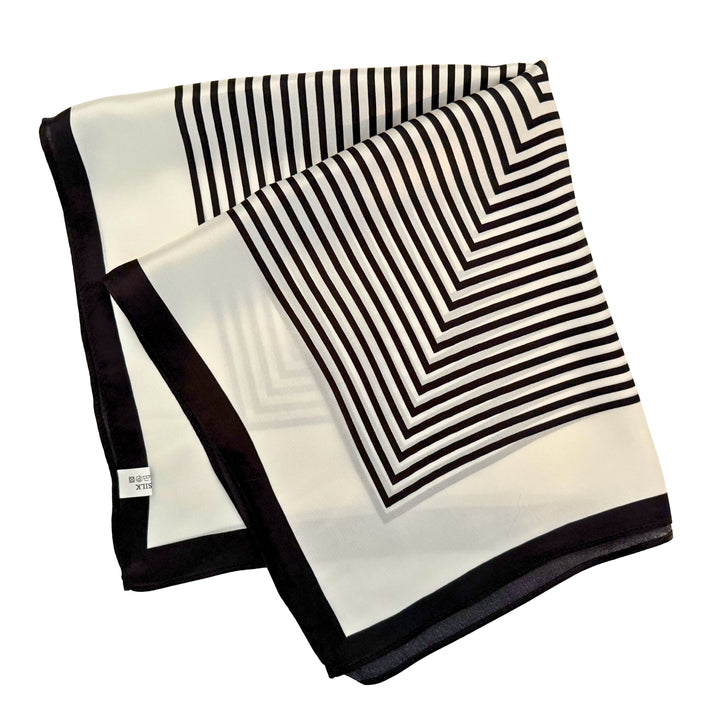 Mulberry silk scarf neatly folded into a square shape showing the geometric labyrinth pattern and contrasting borders.