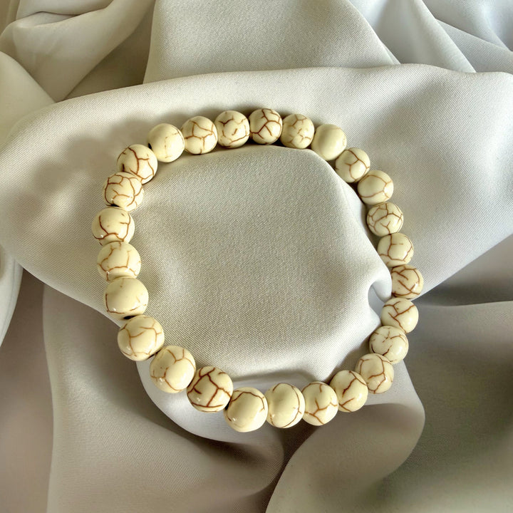 Full view of a handcrafted white howlite bead bracelet on elastic cord.