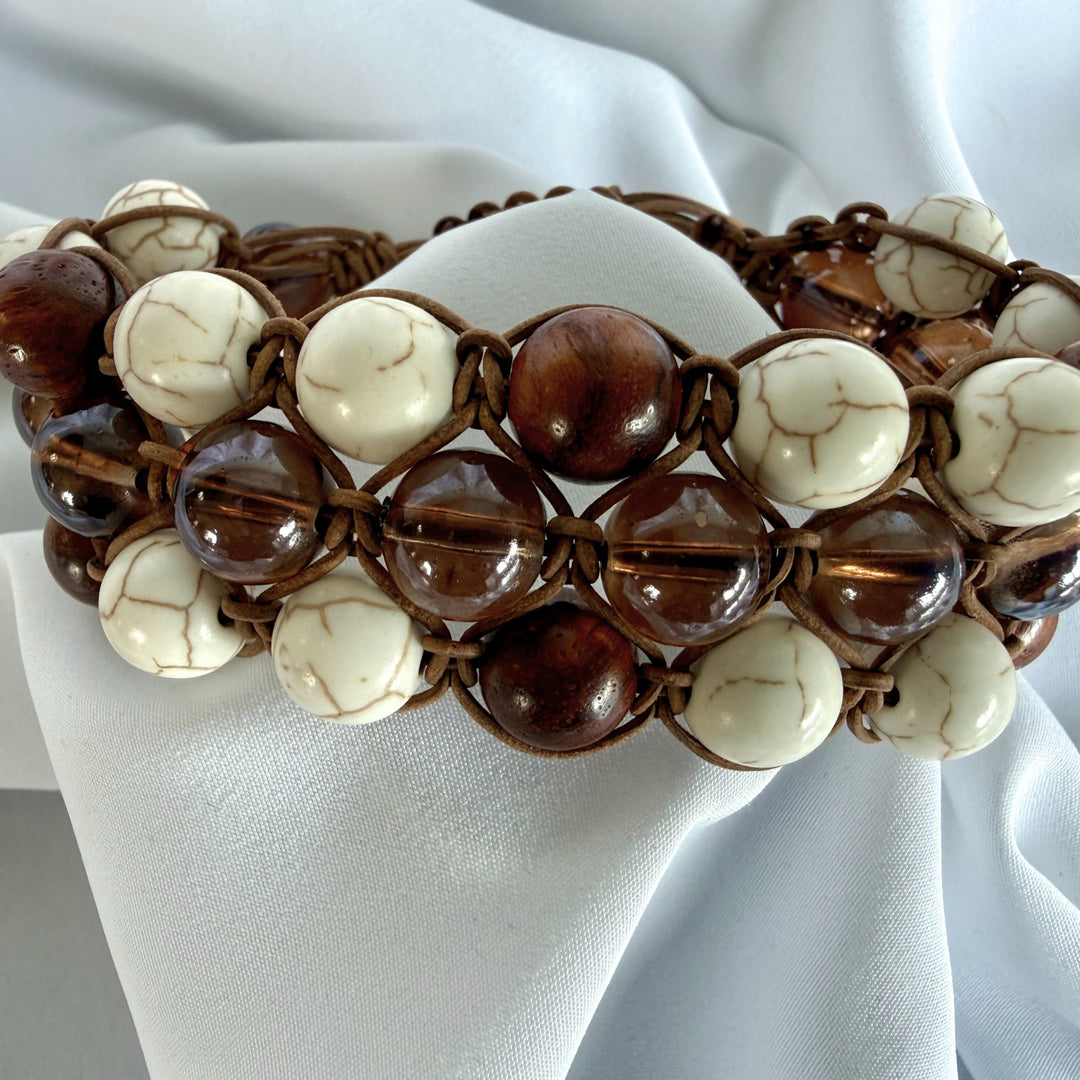 Front view of a handcrafted bracelet combining howlite, wood, and glass beads with brown macramé cord.