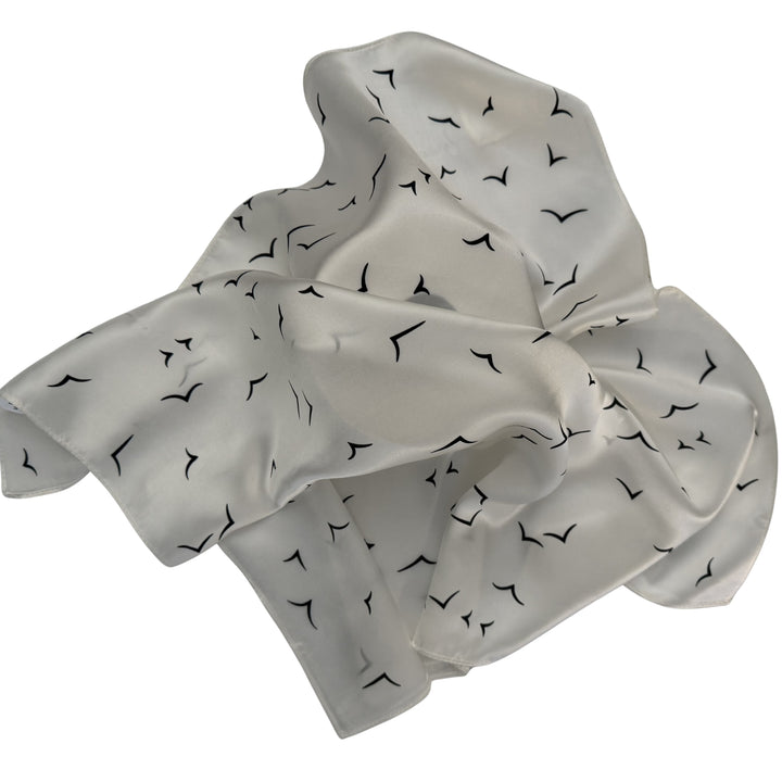 Ivory silk scarf loosely spread to display the full V bird design.