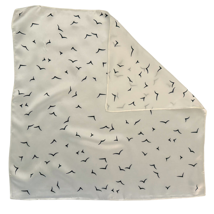 Ivory silk scarf with folded corner showing reverse side and one-sided print.