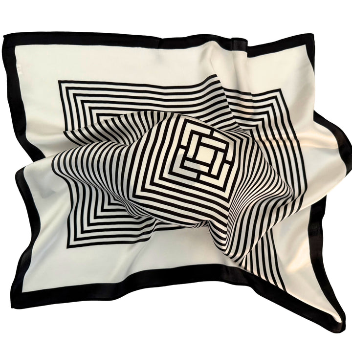 Silk scarf spread out in a relaxed arrangement showcasing the flowing fabric and monochrome labyrinth geometric print.