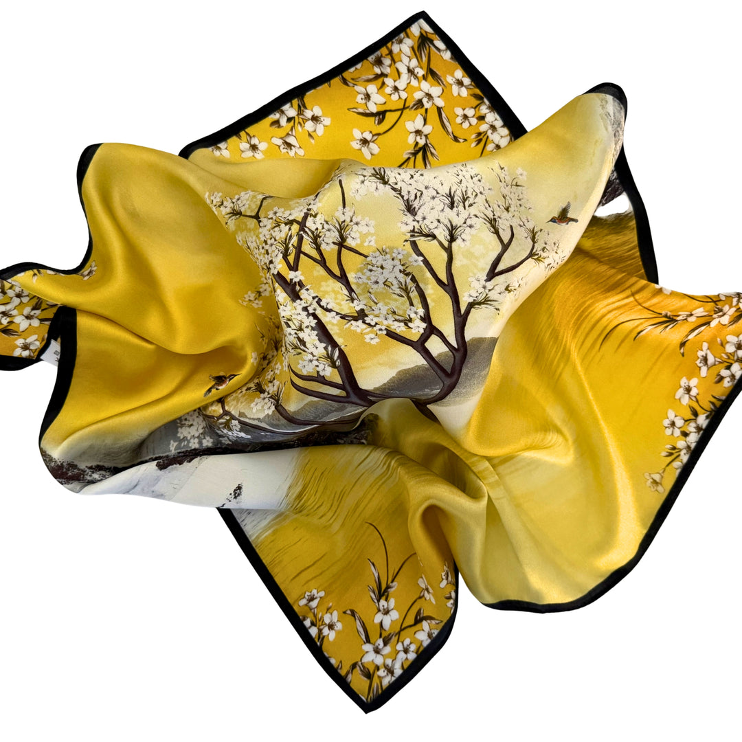 Silk scarf spread out in a relaxed arrangement showcasing the flowing fabric and detailed scenic landscape print.