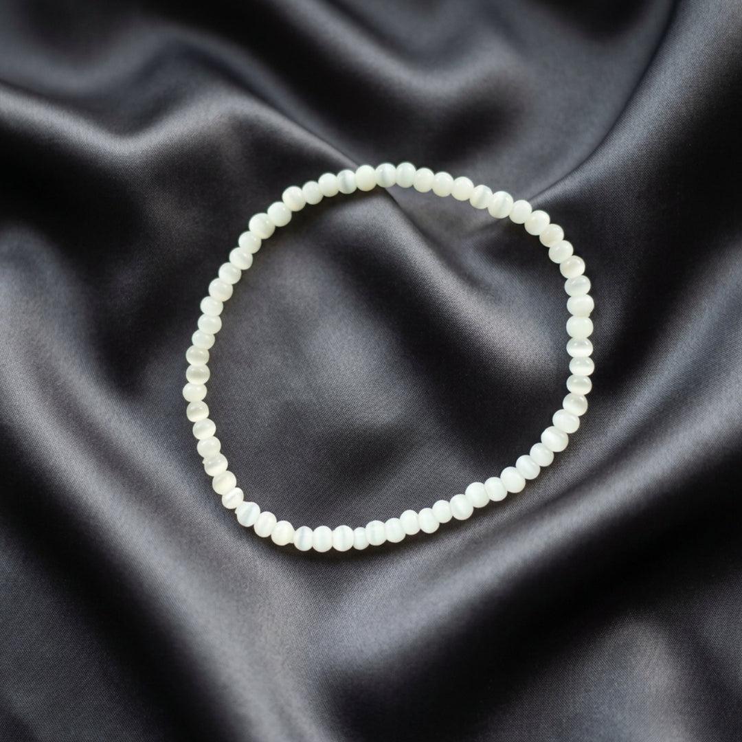 Full view of a handcrafted bracelet made with small light grey beads in a minimalist stackable design.