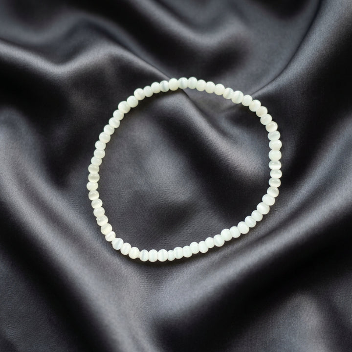 Full view of a handcrafted bracelet made with small light grey beads in a minimalist stackable design.