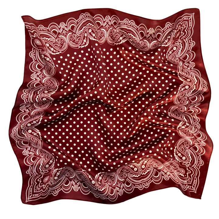 Maroon paisley silk scarf softly laid out in a relaxed arrangement.