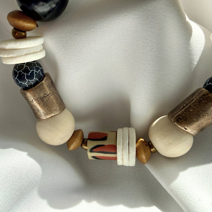 Close-up top view of a handcrafted bracelet showing crackle agate gemstones and animal print polymer clay bead details.