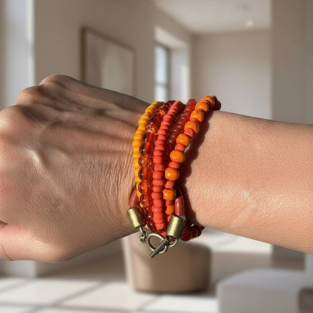Handcrafted multi-strand beaded bracelet with wood and glass beads worn on a wrist, showing warm earthy tones and layered structure.