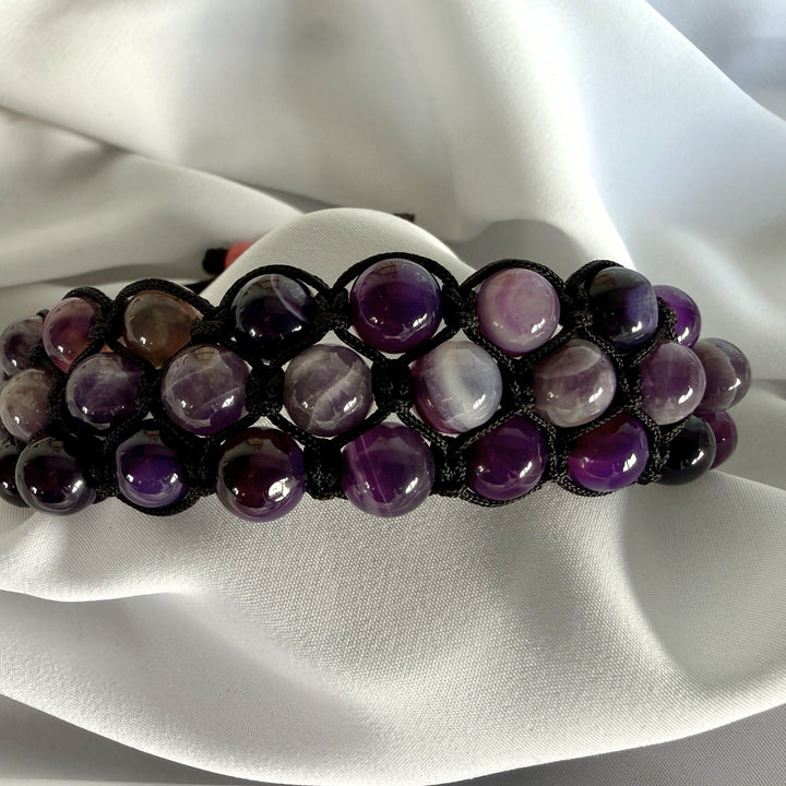 Front view of a handcrafted amethyst macramé bracelet showing rich purple natural stone colours.