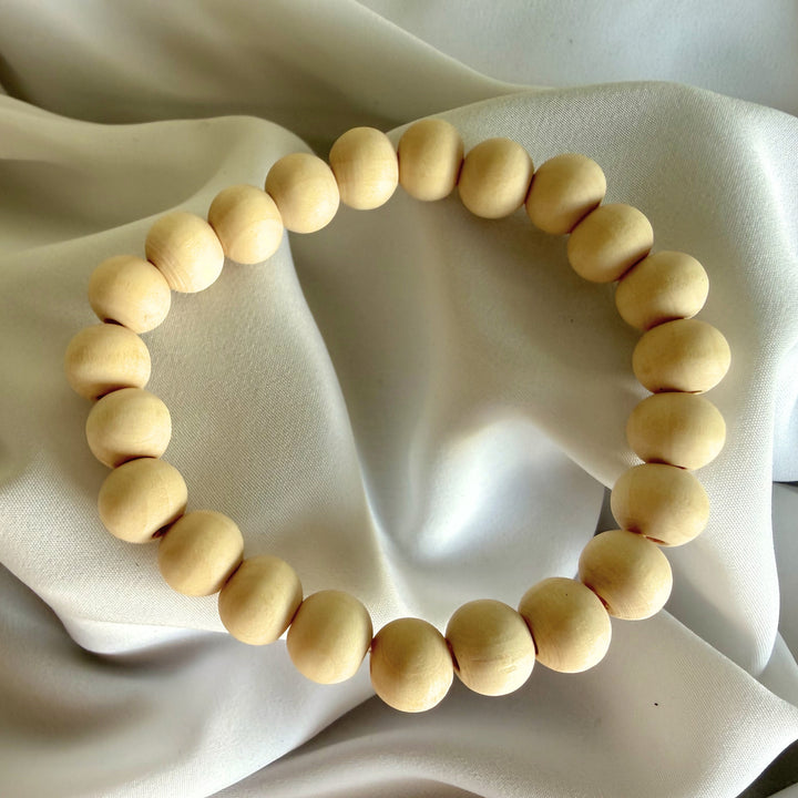 Full view of a handcrafted bracelet made with natural wood beads on elastic cord.