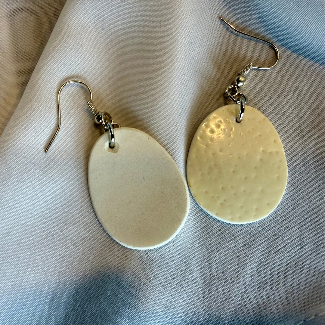Handcrafted ostrich eggshell drop earrings shown with one earring flipped to reveal the back and natural texture variation.