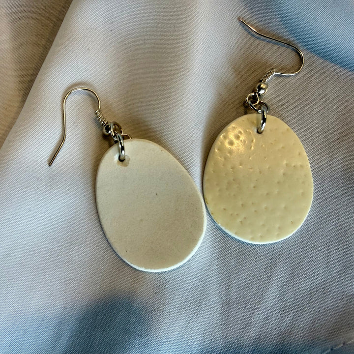 Handcrafted ostrich eggshell drop earrings shown with one earring flipped to reveal the back and natural texture variation.