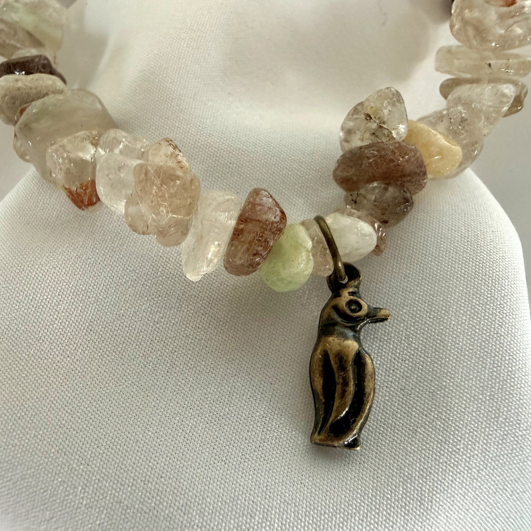 Close-up of a small penguin charm attached to a handcrafted beaded bracelet set.